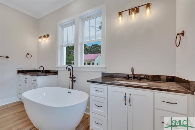 49 Salt Marsh Dr, Midway, GA 31320 - bathroom with a bathing tub, dual bowl vanity, and hardwood / wood-style flooring