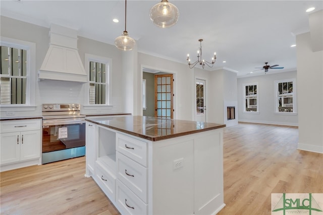 49 Salt Marsh Dr, Midway, GA 31320 - kitchen with decorative light fixtures, a center island, white cabinetry, electric range oven, and light wood-type flooring