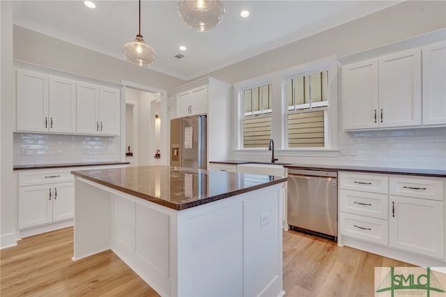 49 Salt Marsh Dr, Midway, GA 31320 - kitchen featuring appliances with stainless steel finishes, tasteful backsplash, a center island, decorative light fixtures, and white cabinets