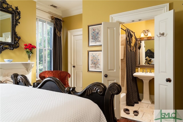 tiled bedroom featuring connected bathroom, ornamental molding, and sink