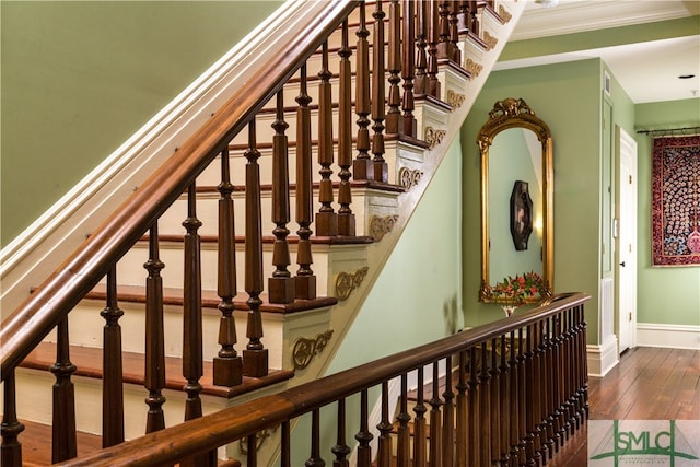 stairs featuring crown molding and hardwood / wood-style floors