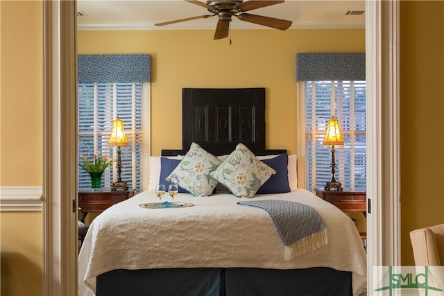 bedroom with multiple windows, ceiling fan, and ornamental molding