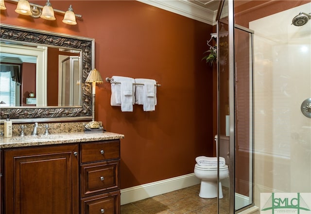 bathroom with toilet, vanity, an enclosed shower, and ornamental molding