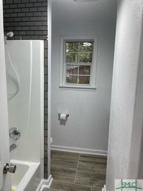 bathroom featuring  shower combination, toilet, and hardwood / wood-style floors