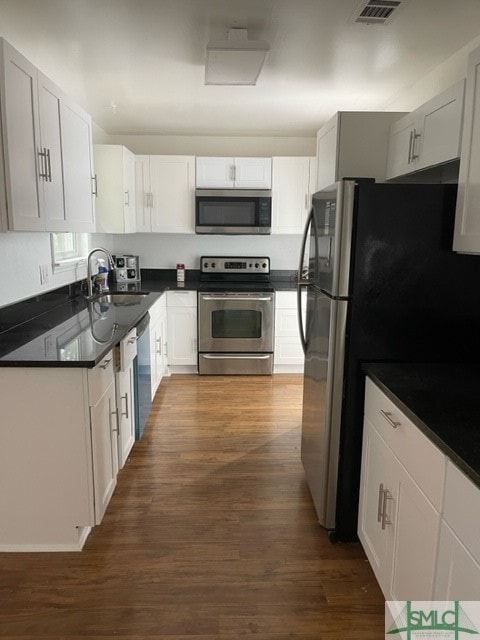 kitchen with white cabinetry, dark hardwood / wood-style floors, sink, and stainless steel appliances