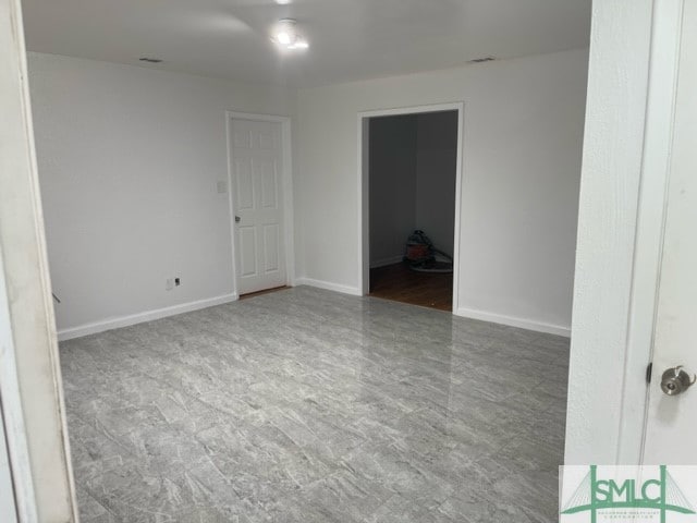 unfurnished room featuring dark tile floors