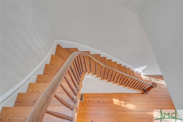 stairs featuring hardwood / wood-style floors