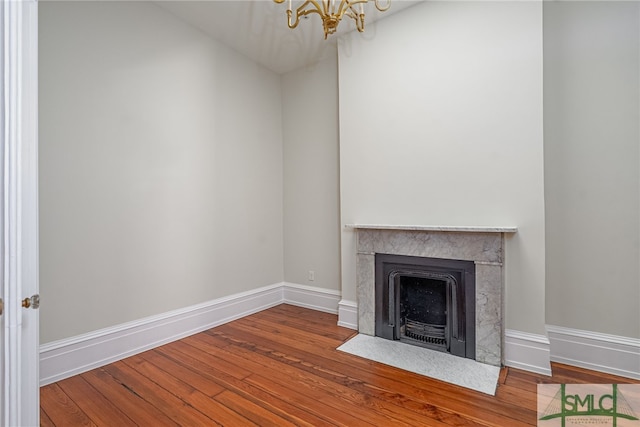 unfurnished living room with hardwood / wood-style flooring and an inviting chandelier