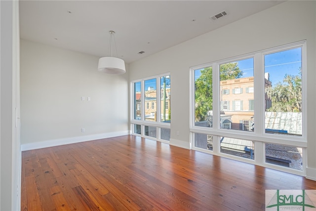 unfurnished living room featuring hardwood / wood-style flooring and a wealth of natural light