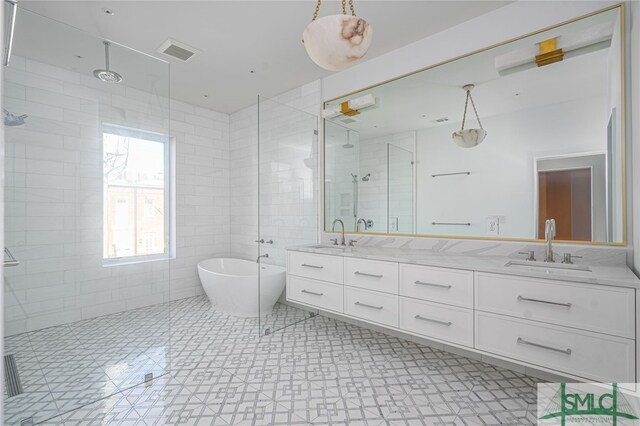 bathroom featuring shower with separate bathtub, vanity, and tile walls