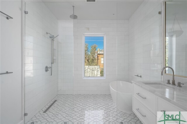 bathroom with vanity and shower with separate bathtub