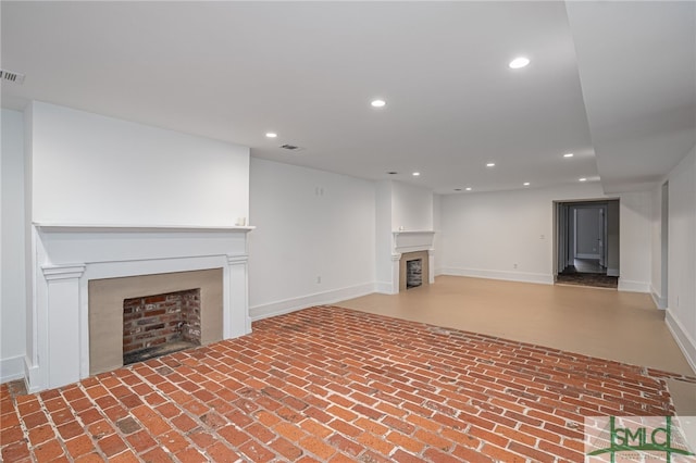 unfurnished living room featuring visible vents, recessed lighting, a fireplace, brick floor, and baseboards