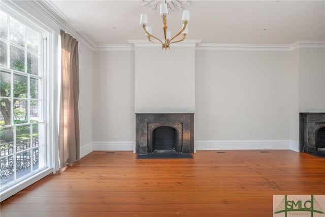 unfurnished living room with a chandelier, hardwood / wood-style floors, and a healthy amount of sunlight