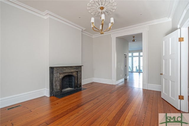 unfurnished living room with a chandelier, hardwood / wood-style floors, and ornamental molding