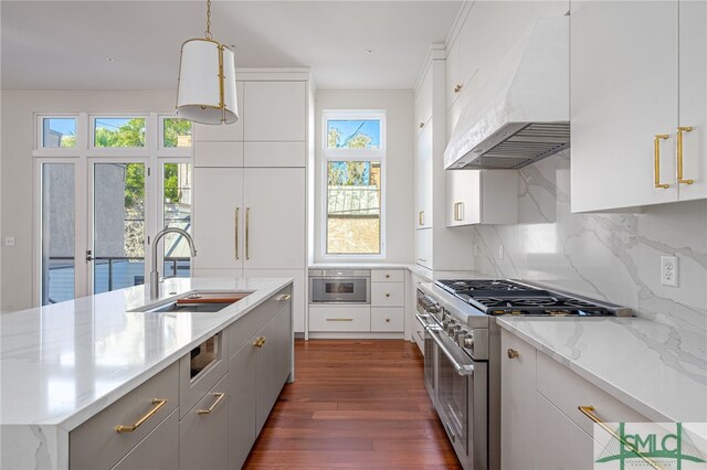 kitchen featuring premium range hood, pendant lighting, white cabinets, and stainless steel appliances