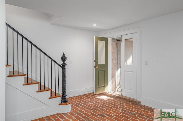 foyer featuring stairs, brick floor, recessed lighting, and baseboards