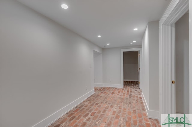 hall featuring brick floor, recessed lighting, and baseboards