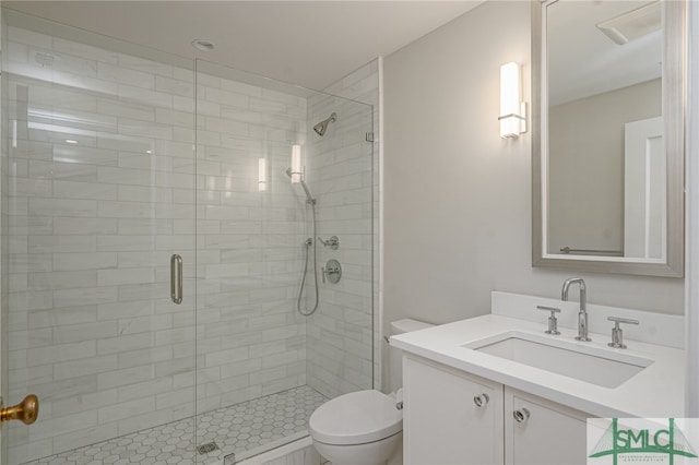 bathroom featuring vanity, a shower with shower door, and toilet