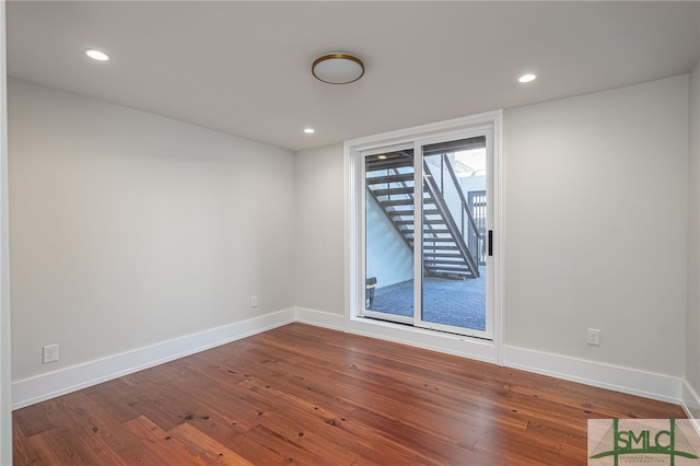 unfurnished room with recessed lighting, dark wood-style floors, and baseboards