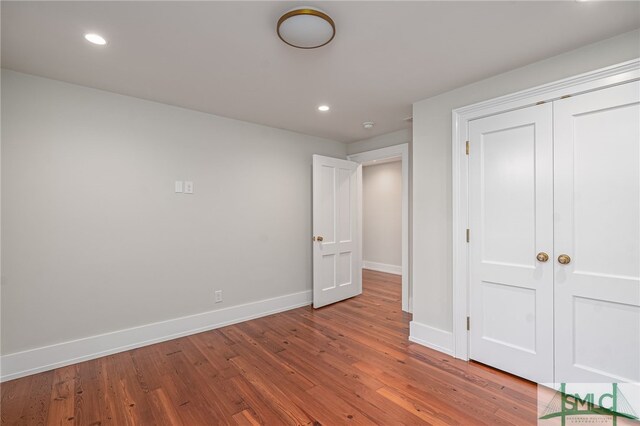 unfurnished bedroom featuring a closet and hardwood / wood-style flooring