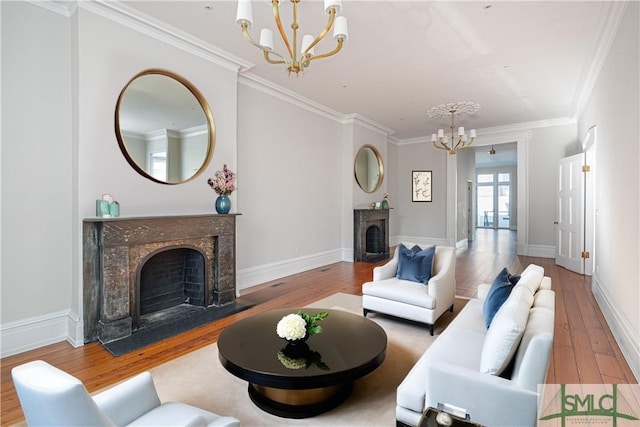 living room featuring hardwood / wood-style flooring, a notable chandelier, crown molding, and a high end fireplace