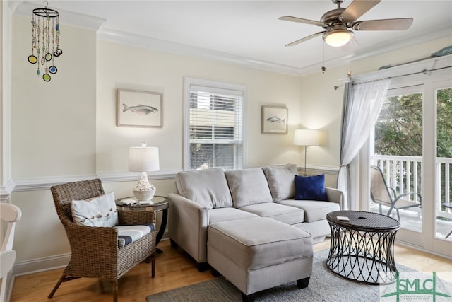 living room with ceiling fan, light wood-type flooring, and ornamental molding