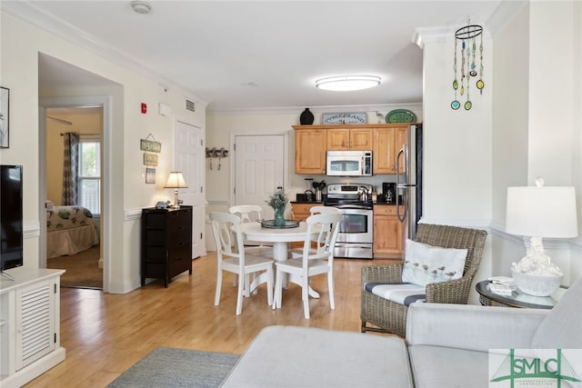 dining room featuring crown molding and light hardwood / wood-style floors