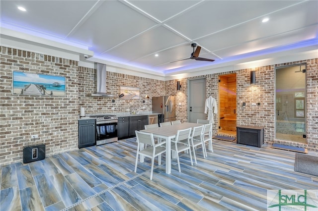 interior space with brick wall, ceiling fan, and light wood-type flooring