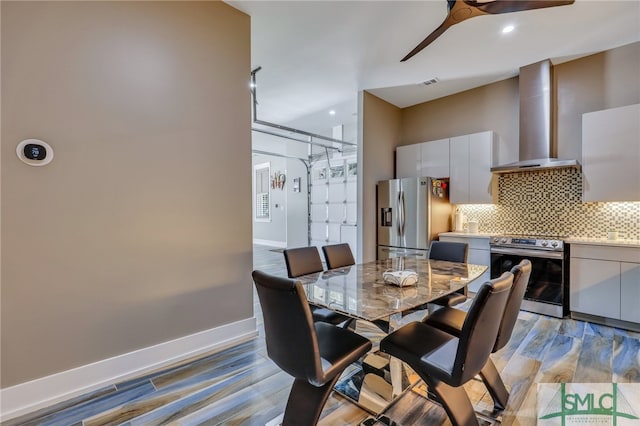 dining area with light hardwood / wood-style floors and ceiling fan