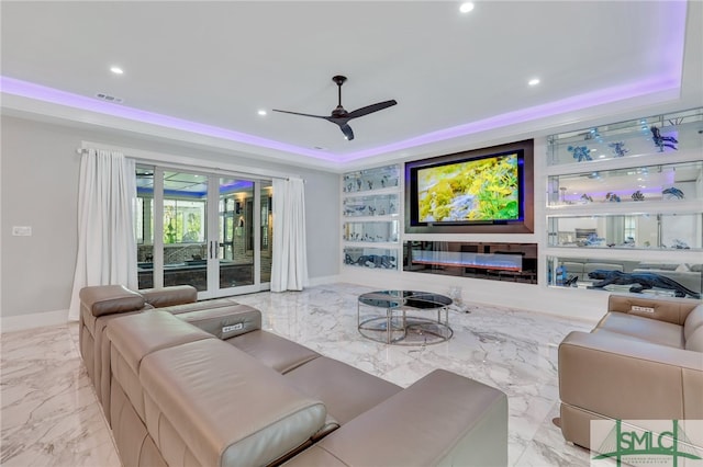 living room featuring light tile floors, a raised ceiling, ceiling fan, and french doors