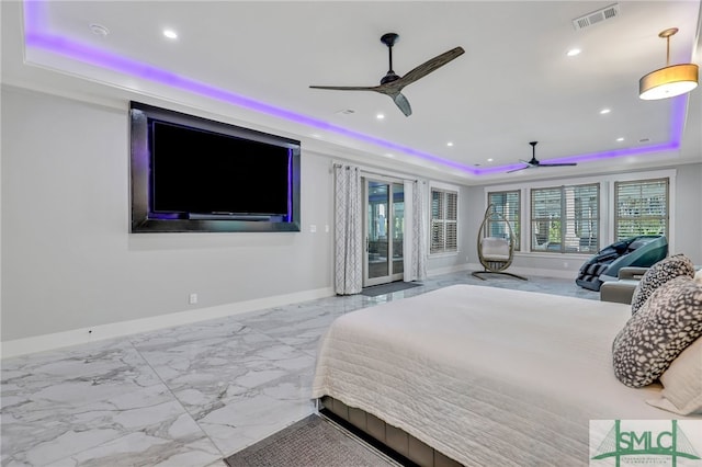 bedroom with ceiling fan, a tray ceiling, and light tile floors