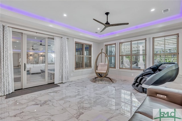 workout room featuring light tile floors, a tray ceiling, and ceiling fan