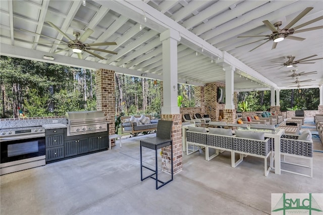 view of patio / terrace featuring area for grilling, an outdoor living space, ceiling fan, and exterior kitchen