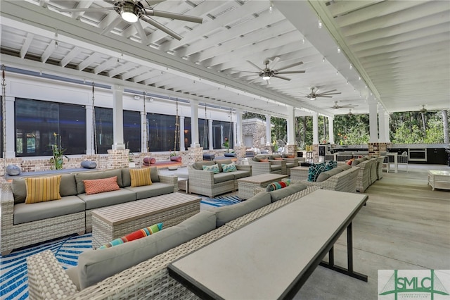 sunroom featuring beam ceiling, ceiling fan, and a wealth of natural light