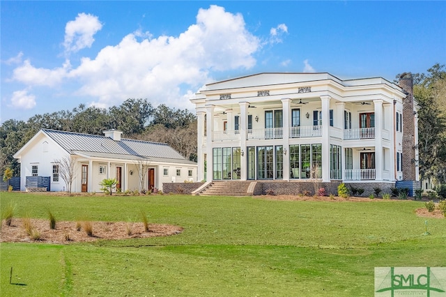 back of house with a lawn and a balcony