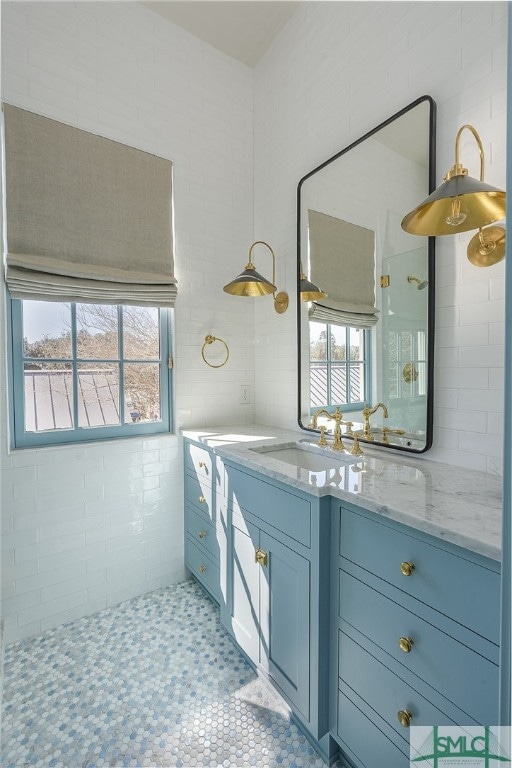 bathroom featuring tile walls, tile flooring, and vanity