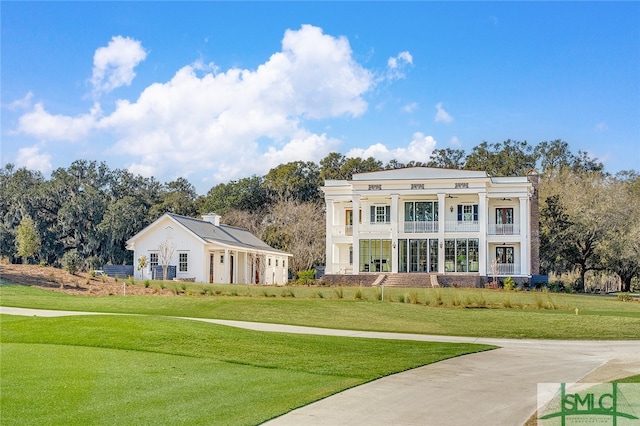 neoclassical / greek revival house featuring a balcony and a front yard