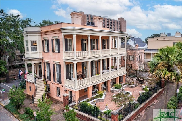 view of property featuring fence and stairs