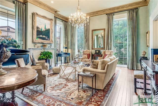 living area with wood-type flooring, an inviting chandelier, and crown molding