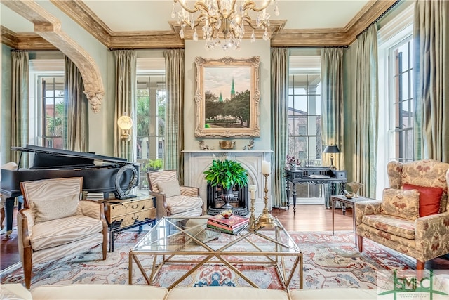 sitting room with ornamental molding, hardwood / wood-style flooring, and a chandelier