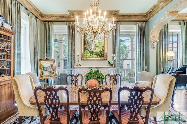 dining space with a notable chandelier, ornamental molding, and hardwood / wood-style floors