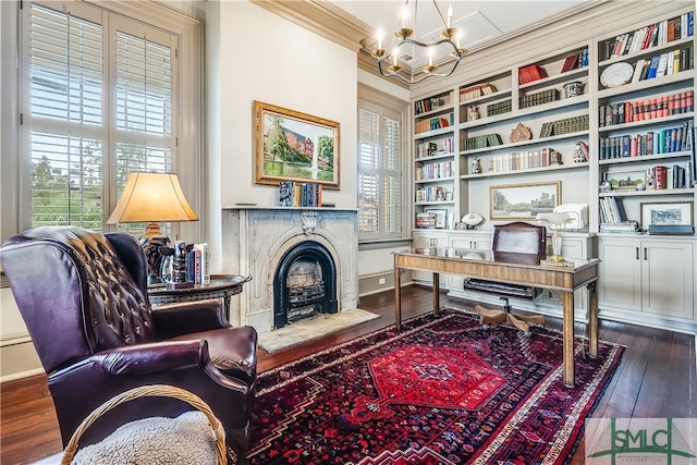 home office with a notable chandelier, dark wood-type flooring, built in features, and ornamental molding