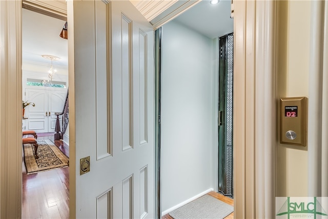 corridor with ornamental molding and hardwood / wood-style flooring