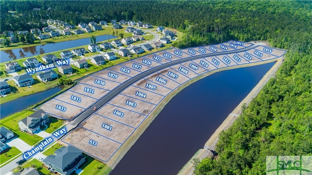 birds eye view of property featuring a water view and a view of trees