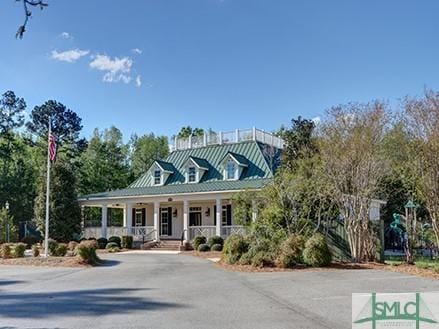 view of front facade with covered porch, metal roof, and a standing seam roof