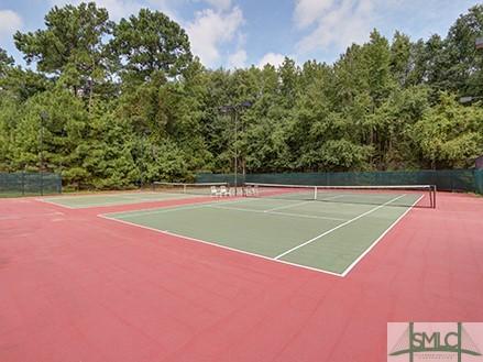 view of tennis court with community basketball court and fence