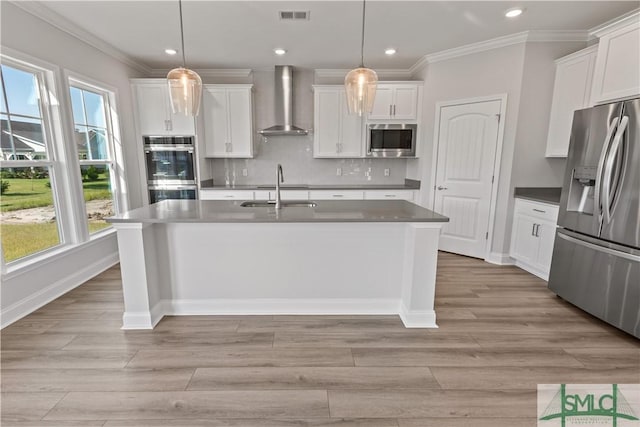 kitchen featuring wall chimney exhaust hood, visible vents, appliances with stainless steel finishes, and decorative light fixtures