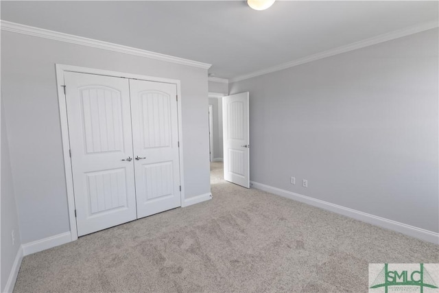 unfurnished bedroom with light carpet, ornamental molding, a closet, and baseboards