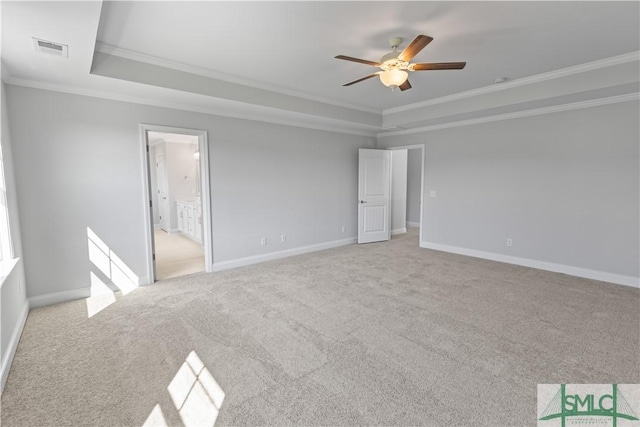 unfurnished bedroom with light colored carpet, a raised ceiling, visible vents, and crown molding