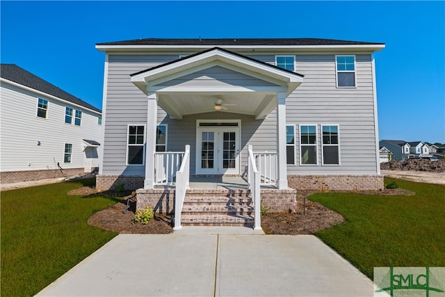 view of front of house featuring a front yard, a ceiling fan, and french doors